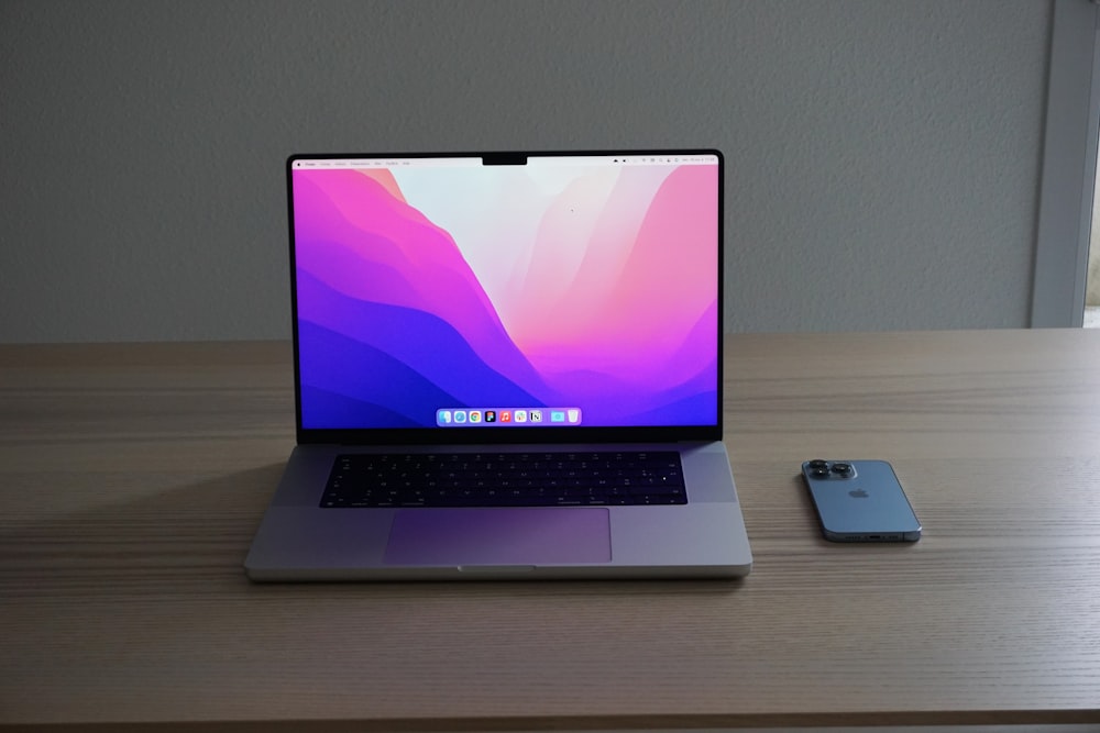 a laptop computer sitting on top of a wooden desk