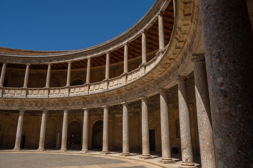 a circular building with columns and a sky background