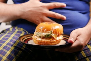 a person holding a plate with a sandwich on it