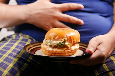 a person holding a plate with a sandwich on it