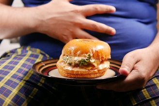 a person holding a plate with a sandwich on it