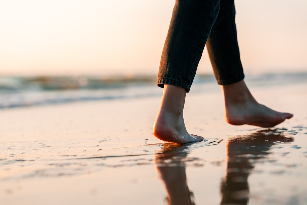 a close up of a person walking on the beach