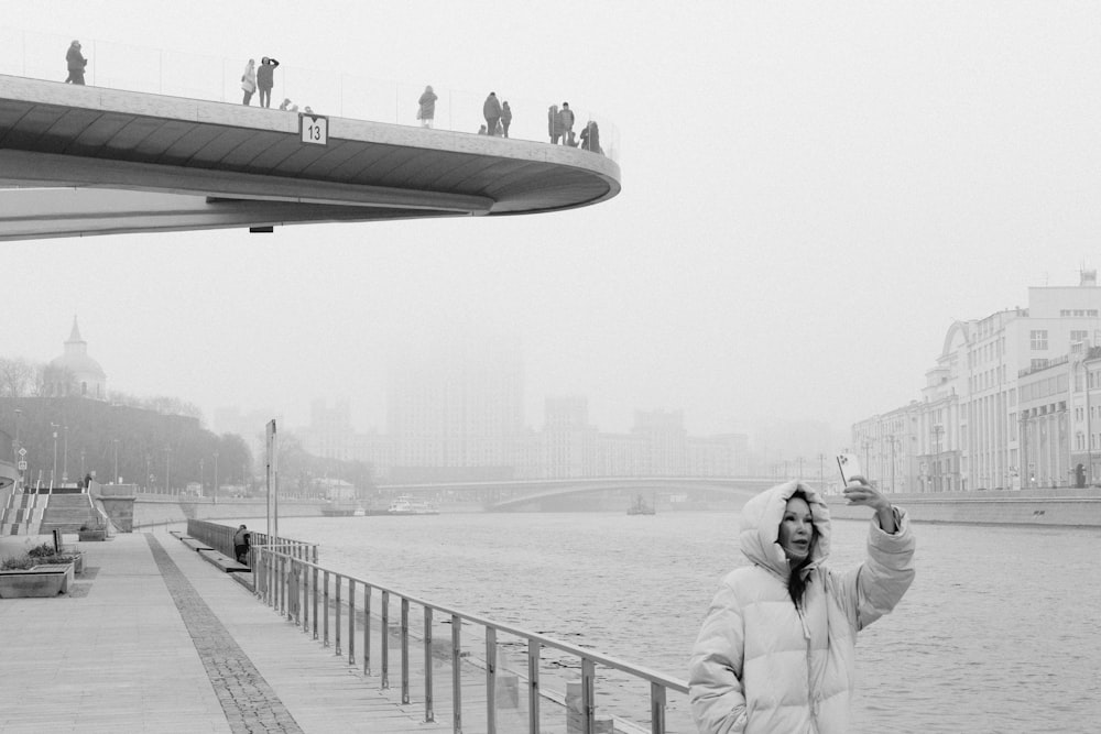 a woman standing on a bridge taking a selfie