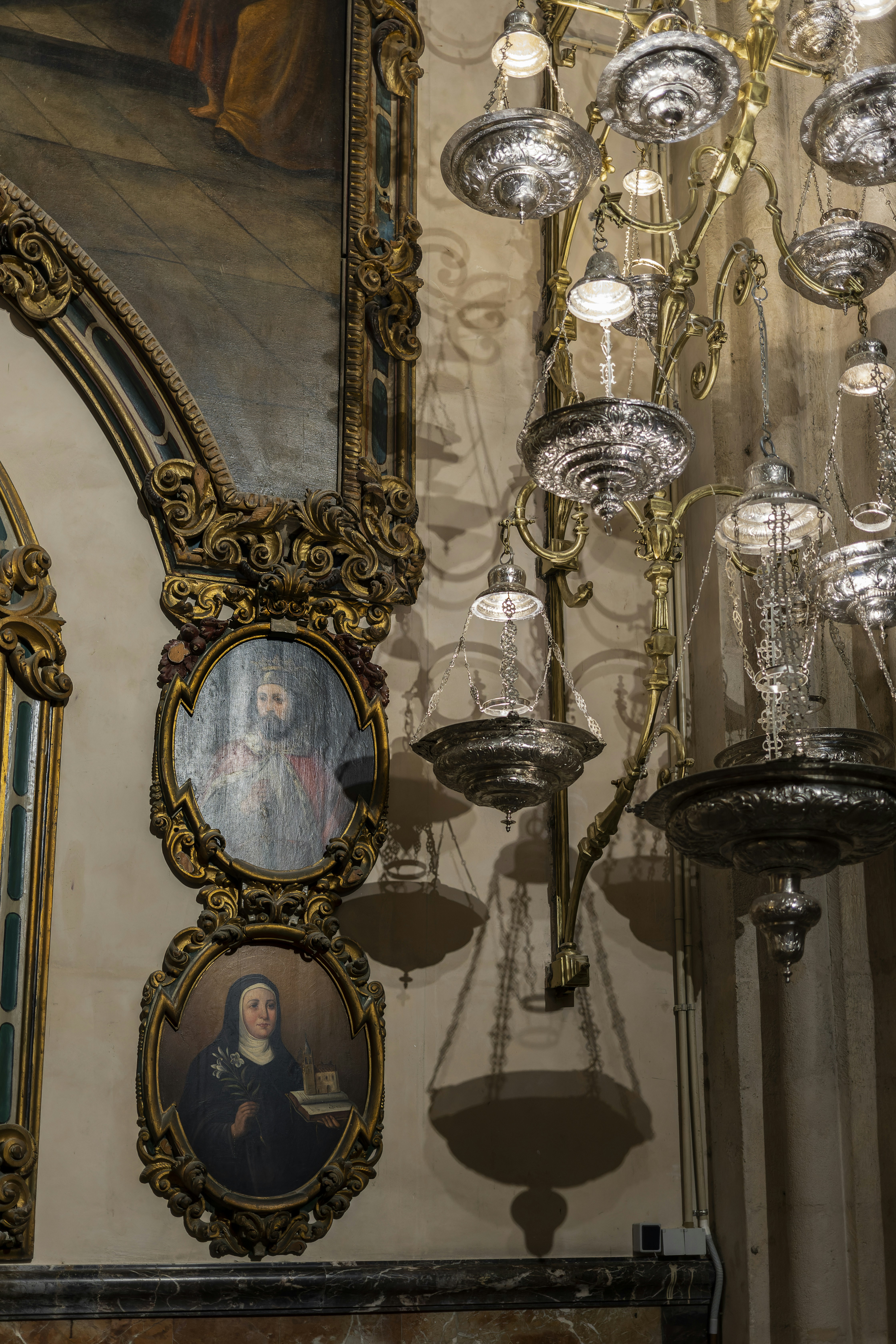 a chandelier hanging from a ceiling next to a painting