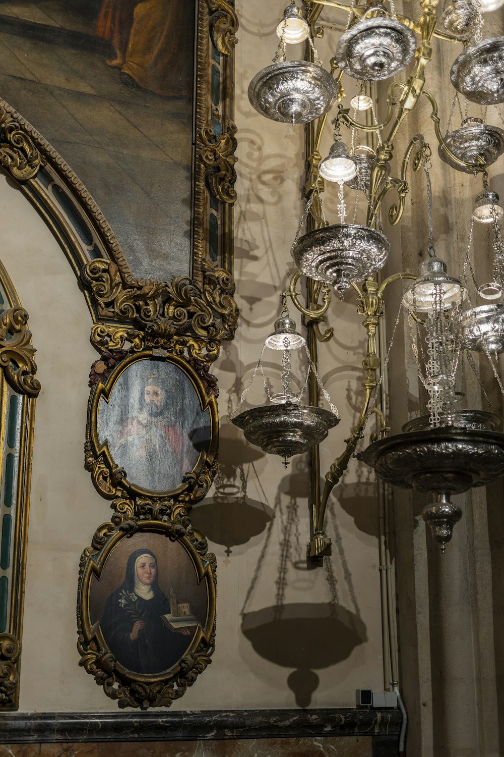 a chandelier hanging from a ceiling next to a painting