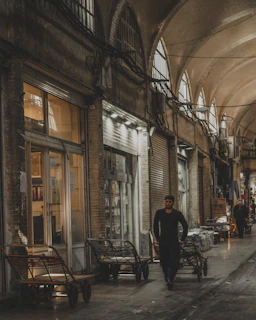 a man walking down a street next to a building