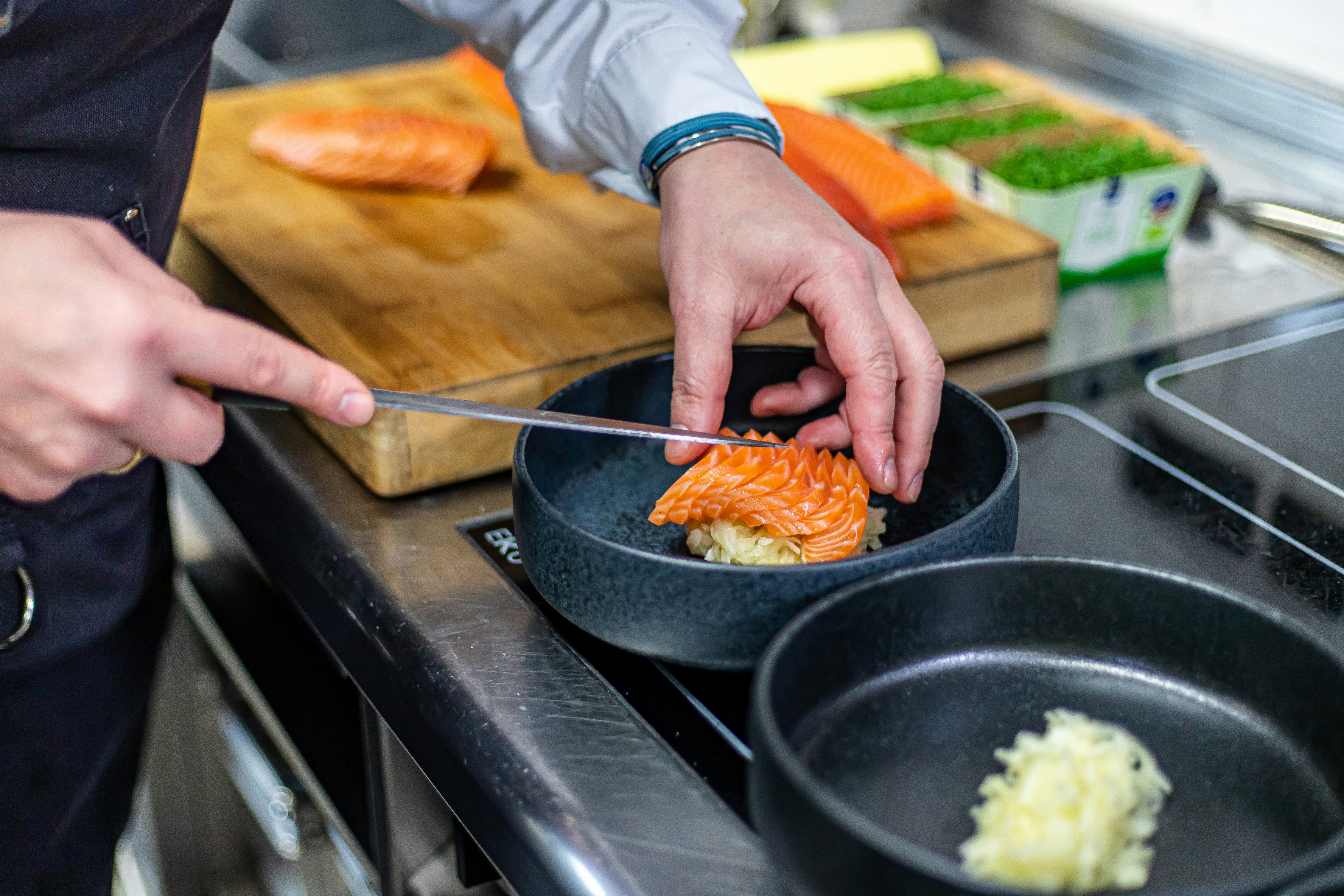 A person in a kitchen preparing food with a knife