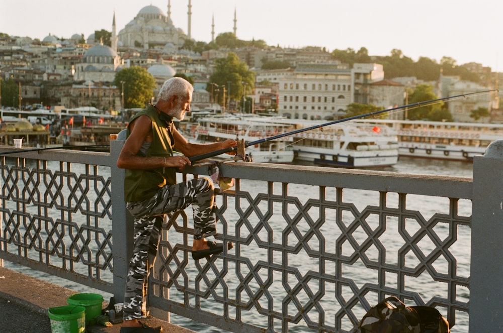 a man fishing on a bridge over a body of water