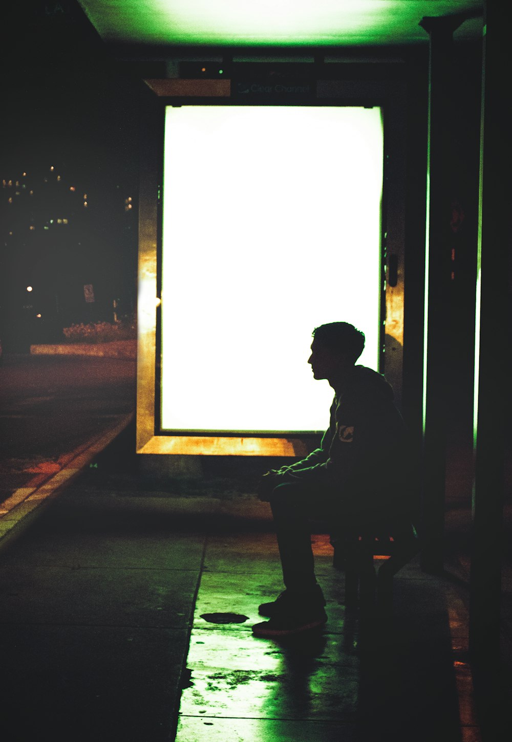 Un uomo seduto su una panchina davanti a una grande finestra