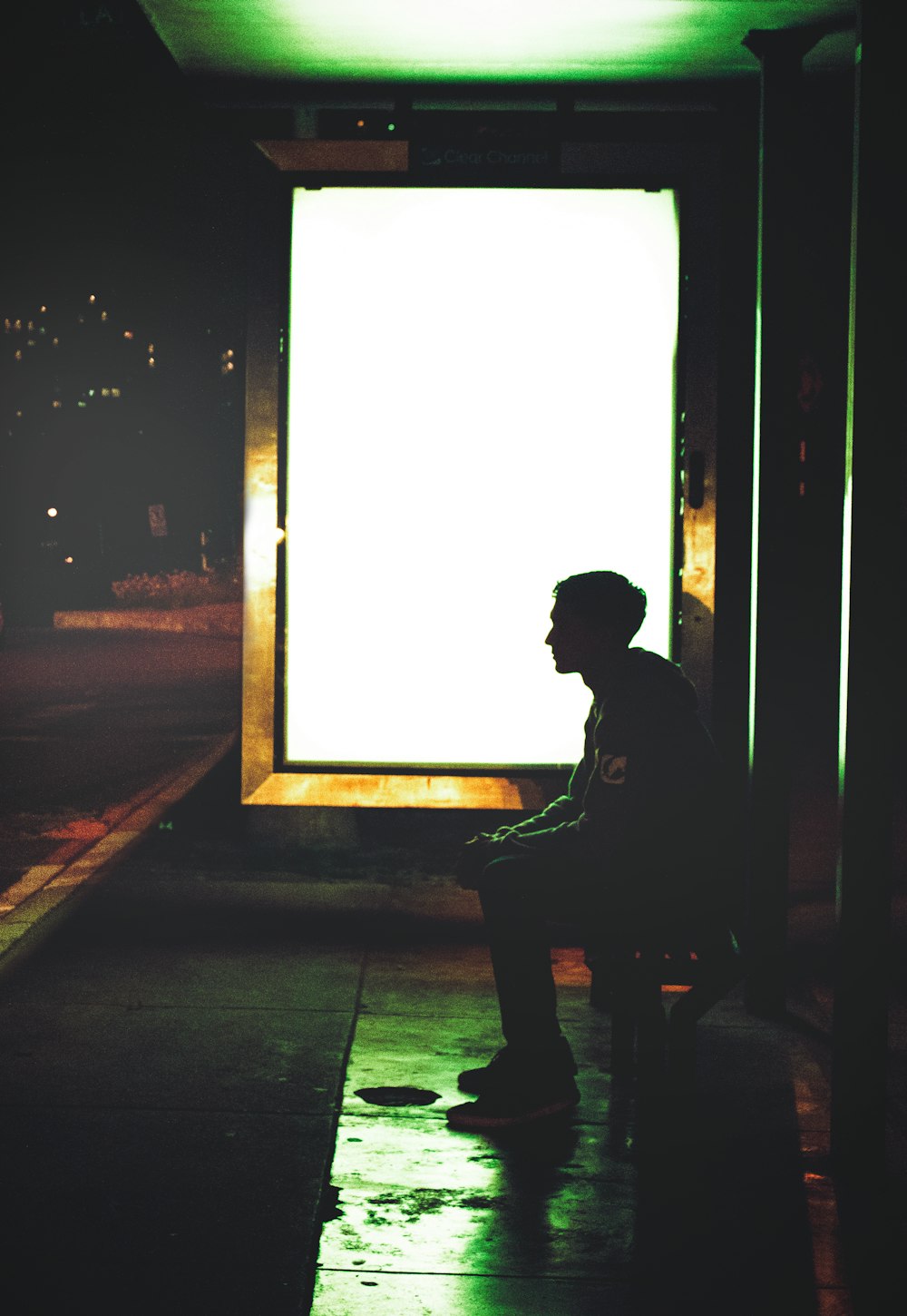 a man sitting on a bench in front of a large window