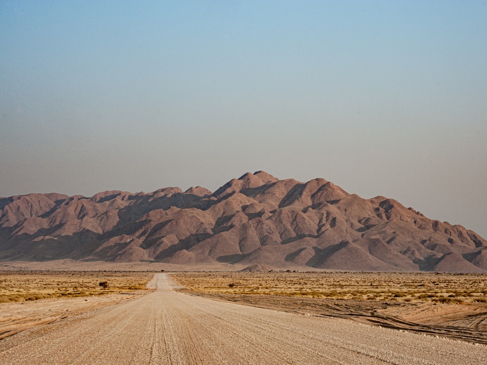 a dirt road with mountains in the background