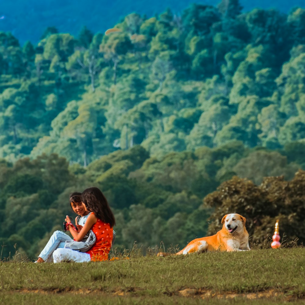 a girl and a dog sitting in a field
