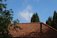 Wide shot of a Barrington home with a newly installed chimney cap under a blue sky.