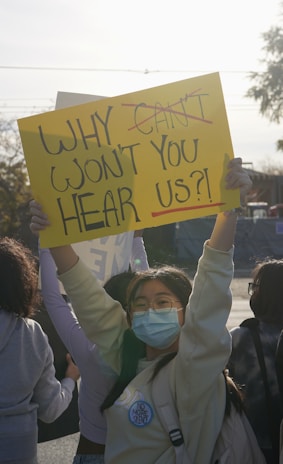 Community members gathered at a local meeting, holding signs demanding government transparency.
