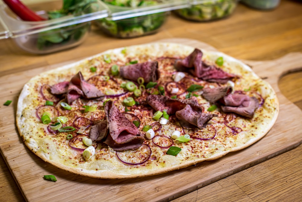 uma pizza sentada em cima de uma tábua de corte de madeira