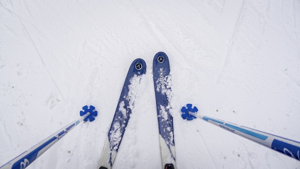 une paire de skis et de bâtons de ski posés dans la neige