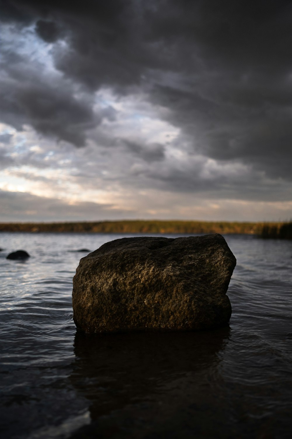 a rock sitting in the middle of a body of water