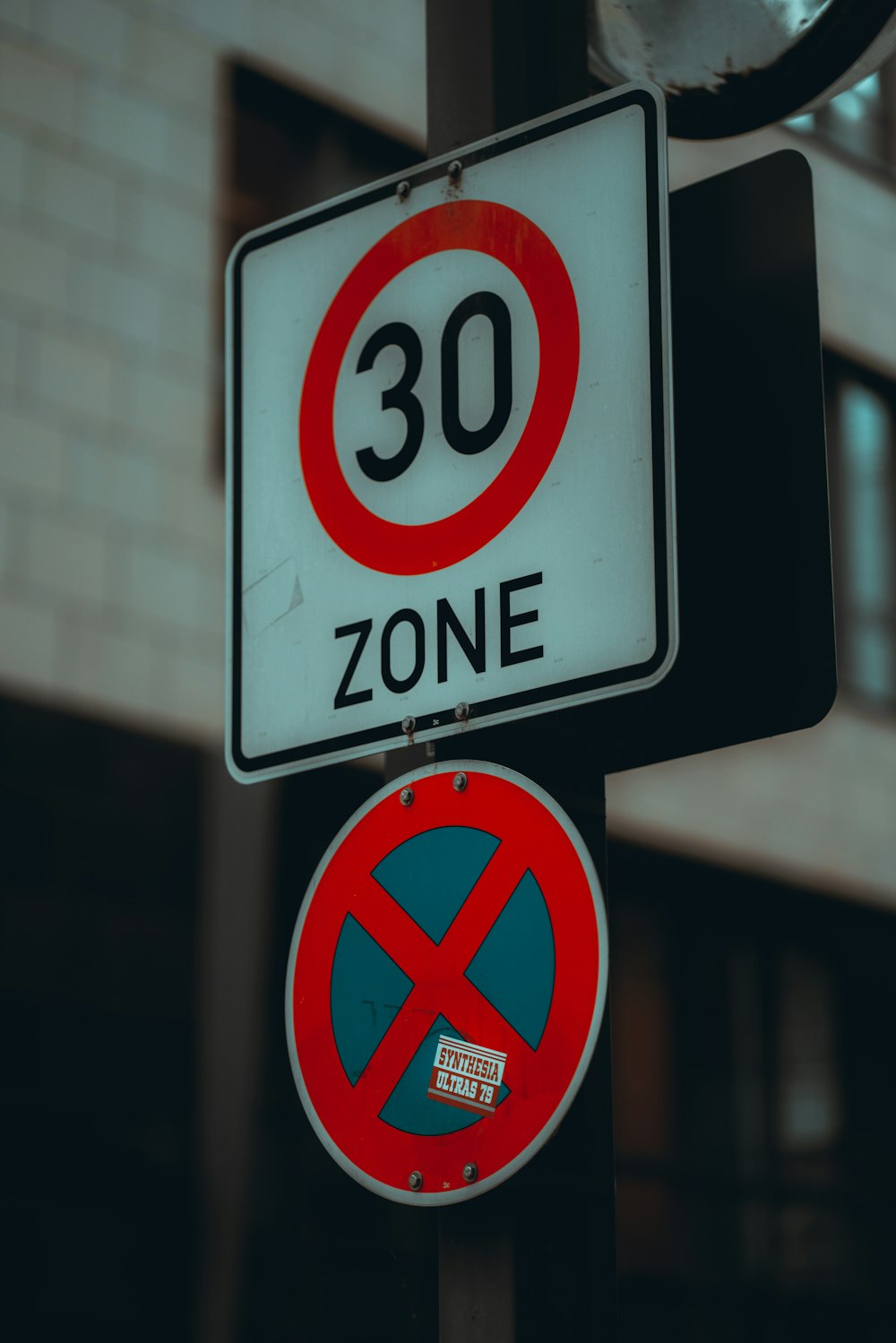 a red and white street sign sitting on top of a traffic light