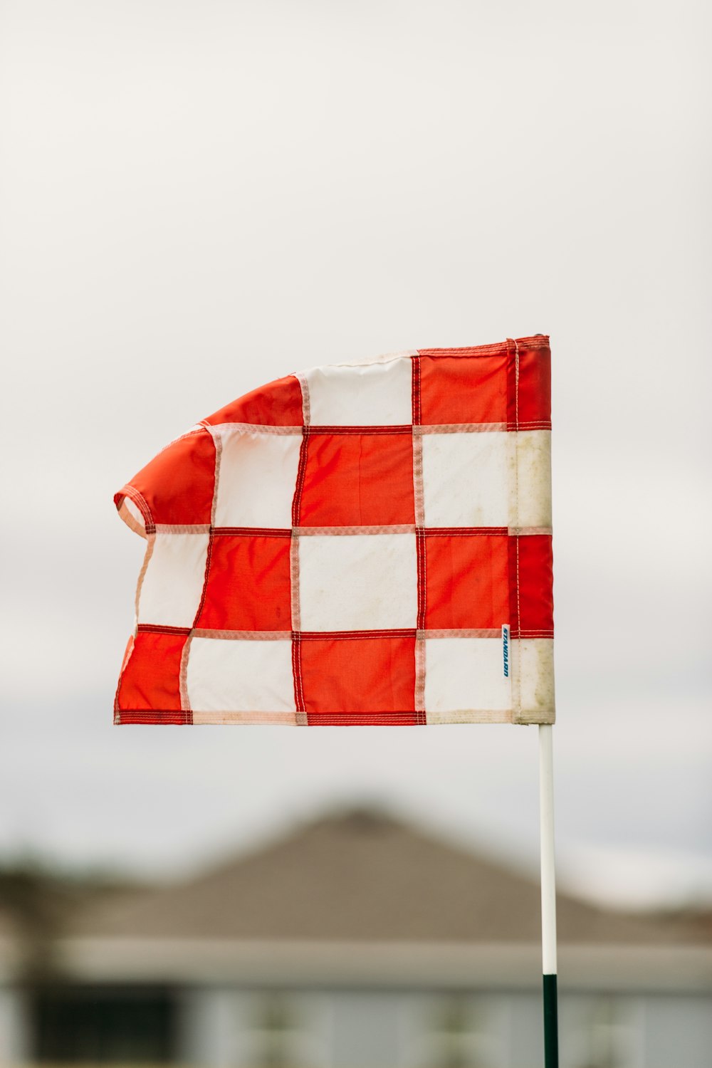 a red and white checkered flag on a pole
