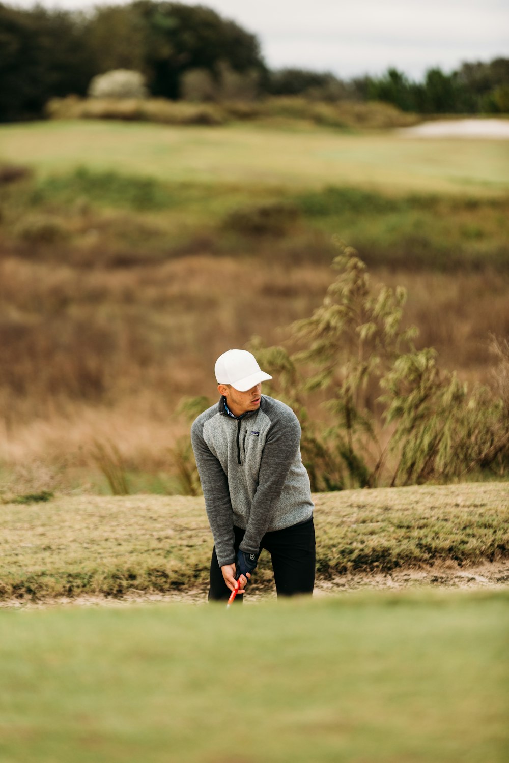 a man holding a golf club on a golf course