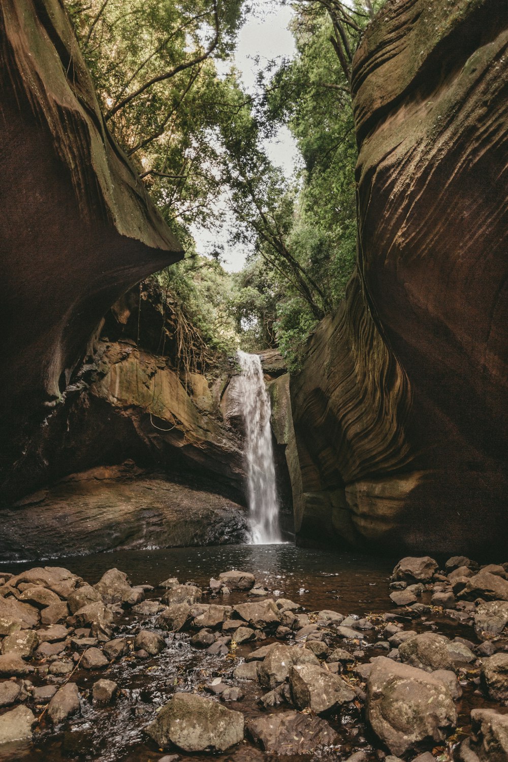 a waterfall in the middle of a canyon