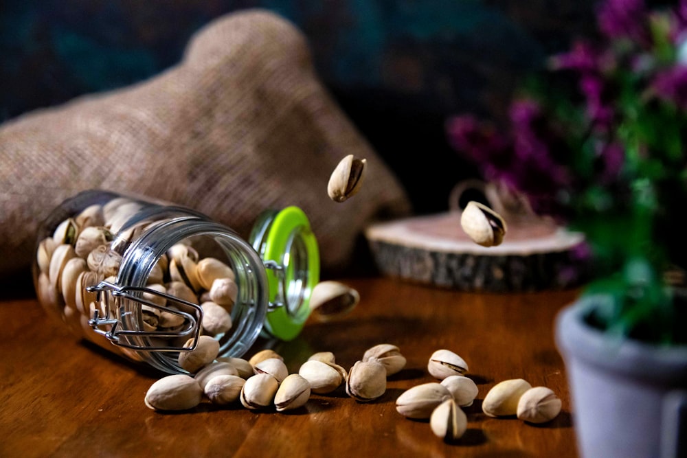 a jar filled with nuts on top of a wooden table