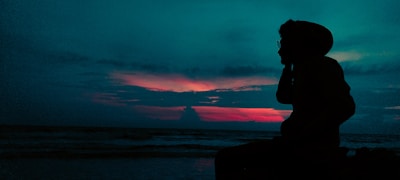 An inspiring silhouette wearing a rockitwithpride hoodie against a sunrise backdrop.