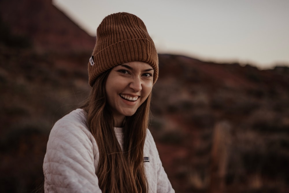 a woman wearing a brown hat and a white jacket