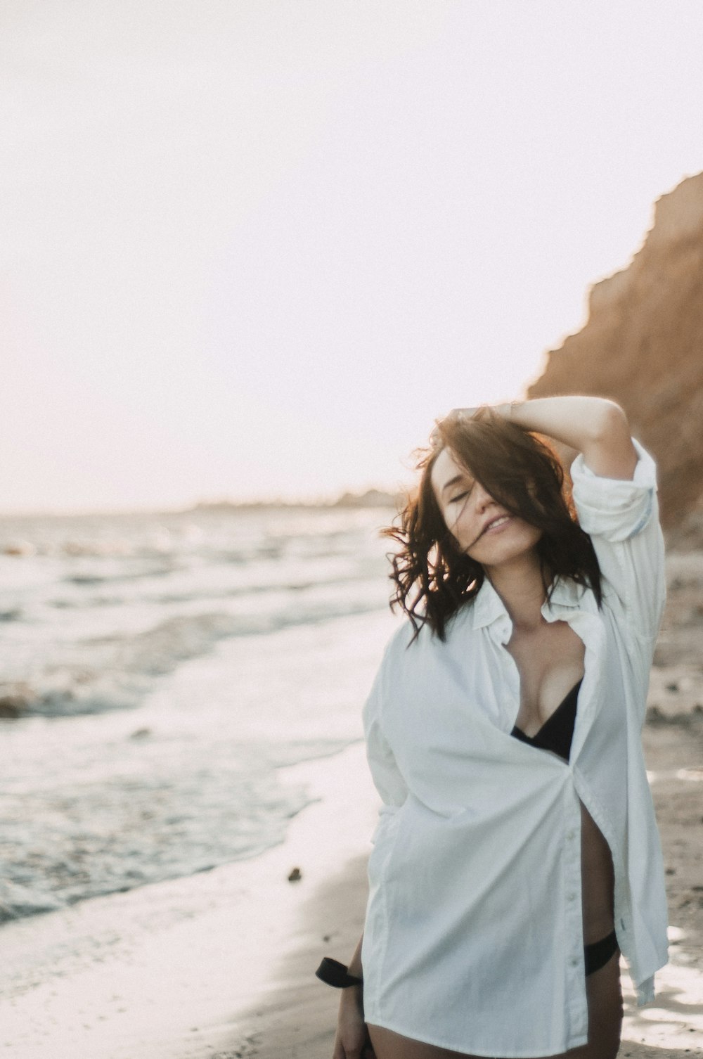 a woman standing on top of a beach next to the ocean