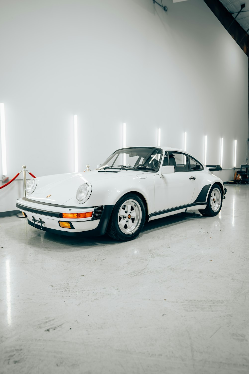 a white car parked in a garage next to another car