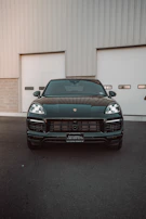 A sleek vehicle ready for transportation assistance, parked in front of a luxury home.