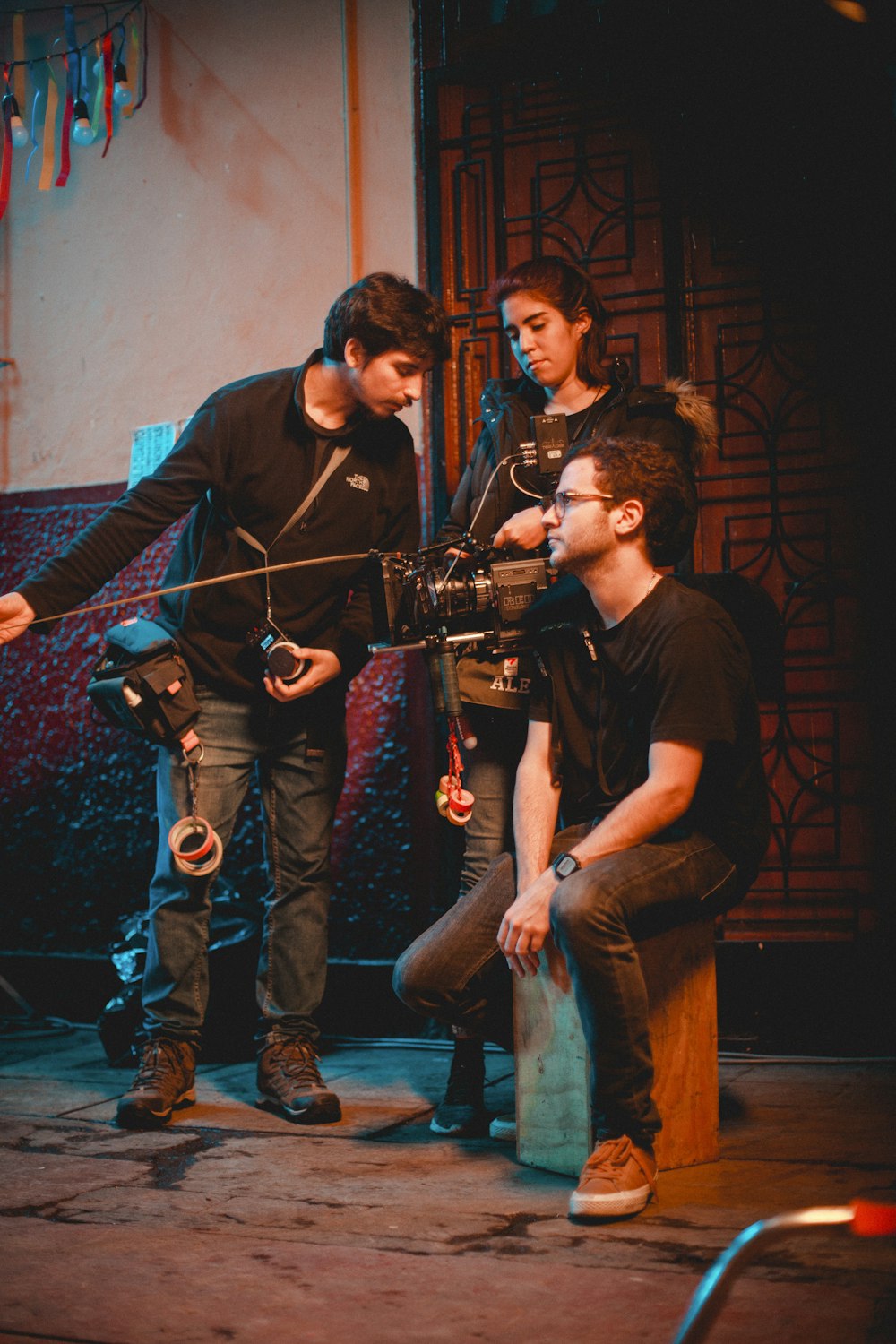 a group of young men standing around a camera