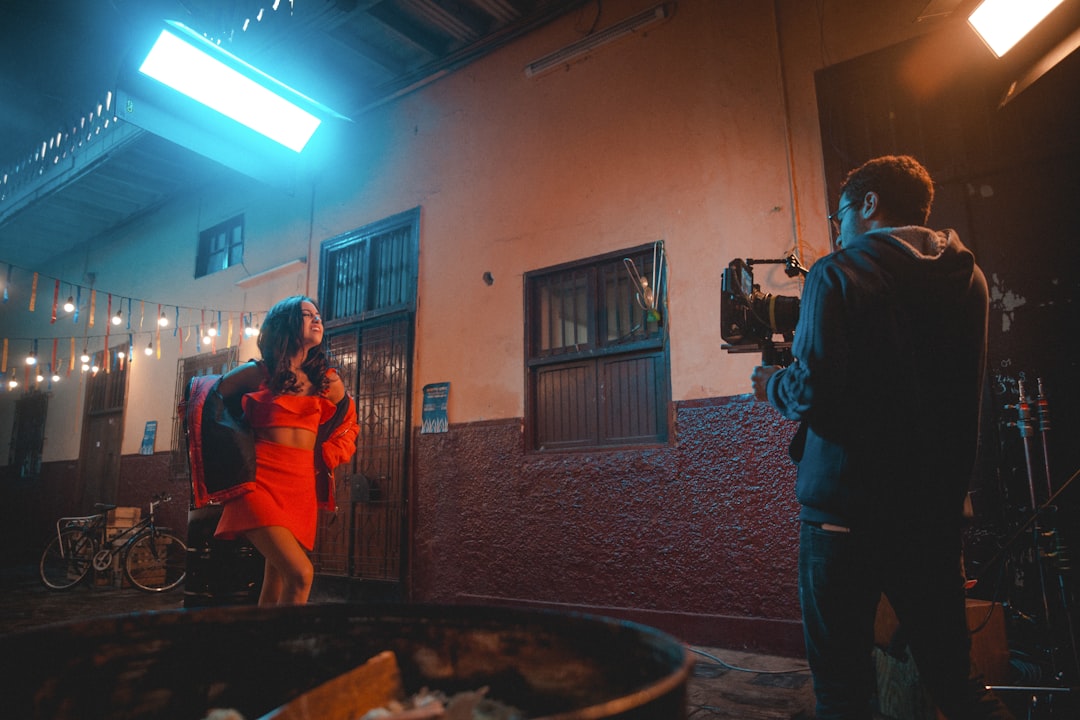 a man standing next to a woman in an orange dress
