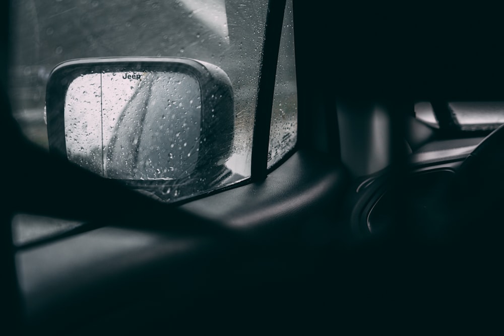 a car's side view mirror with rain drops on it