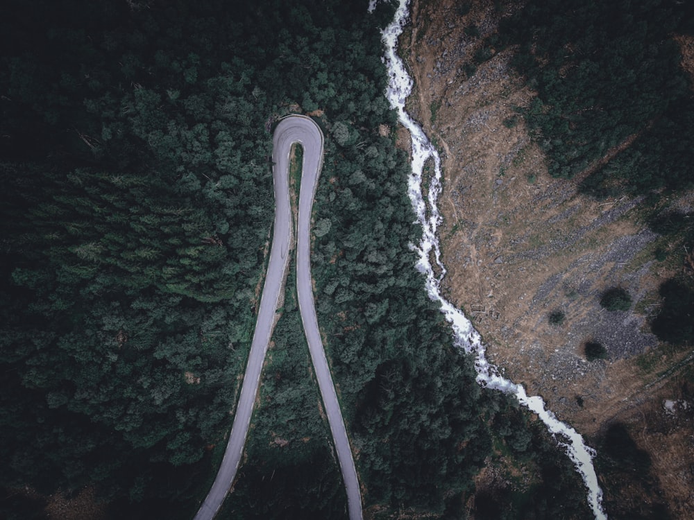 an aerial view of a winding road in the woods