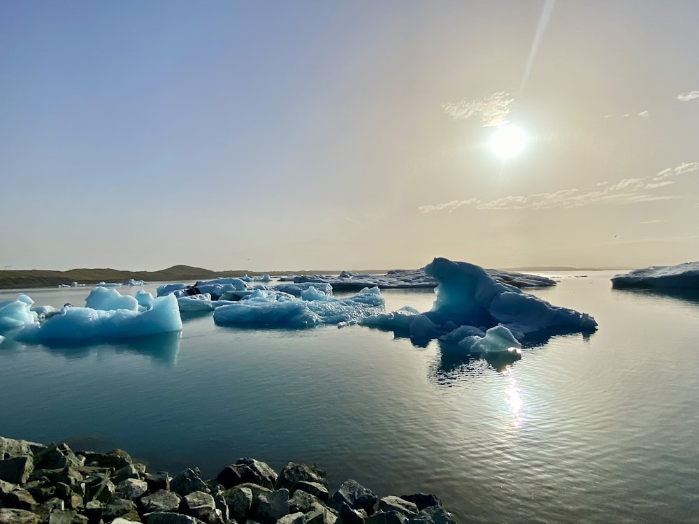 icebergs floating in the water on a sunny day