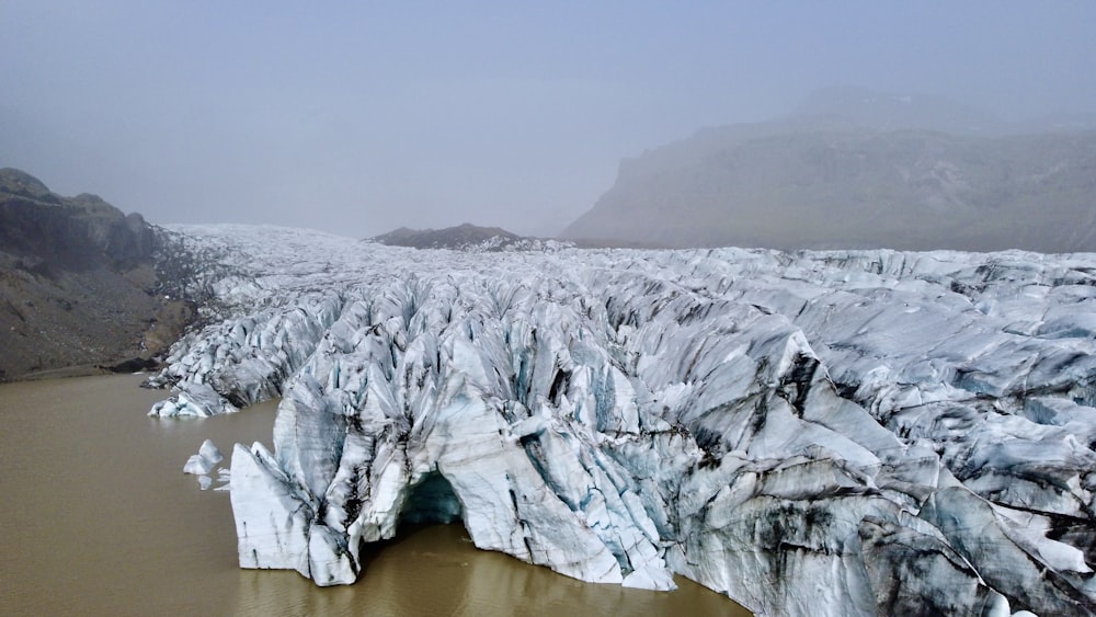 a large glacier with a lake in the middle of it