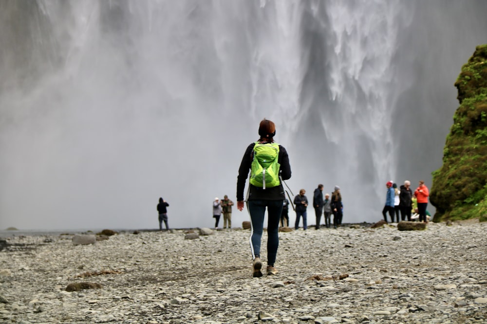 a group of people standing in front of a waterfall