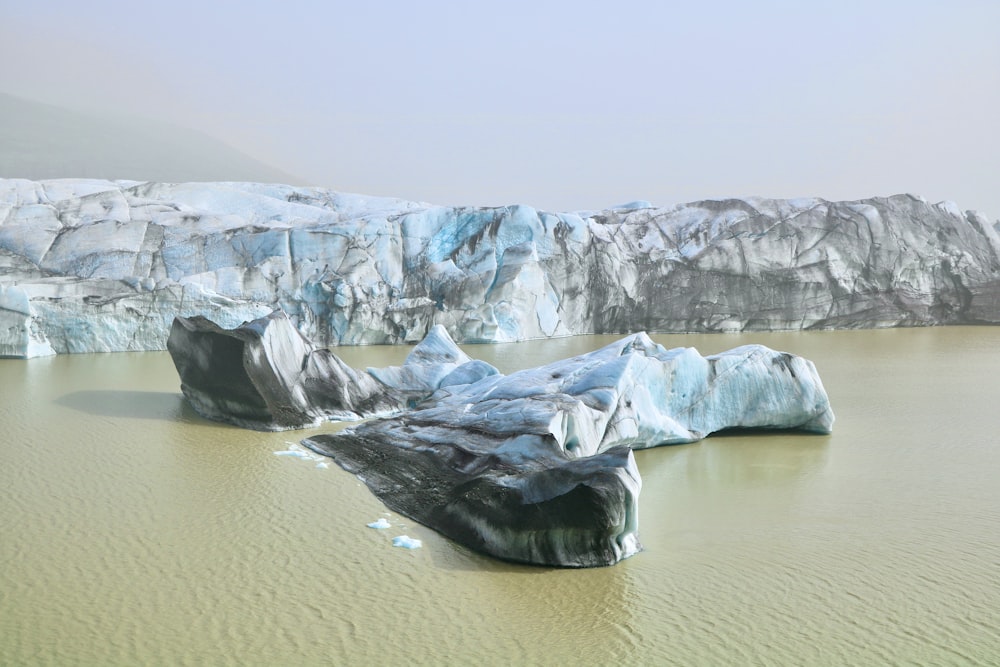 a group of icebergs floating on top of a lake