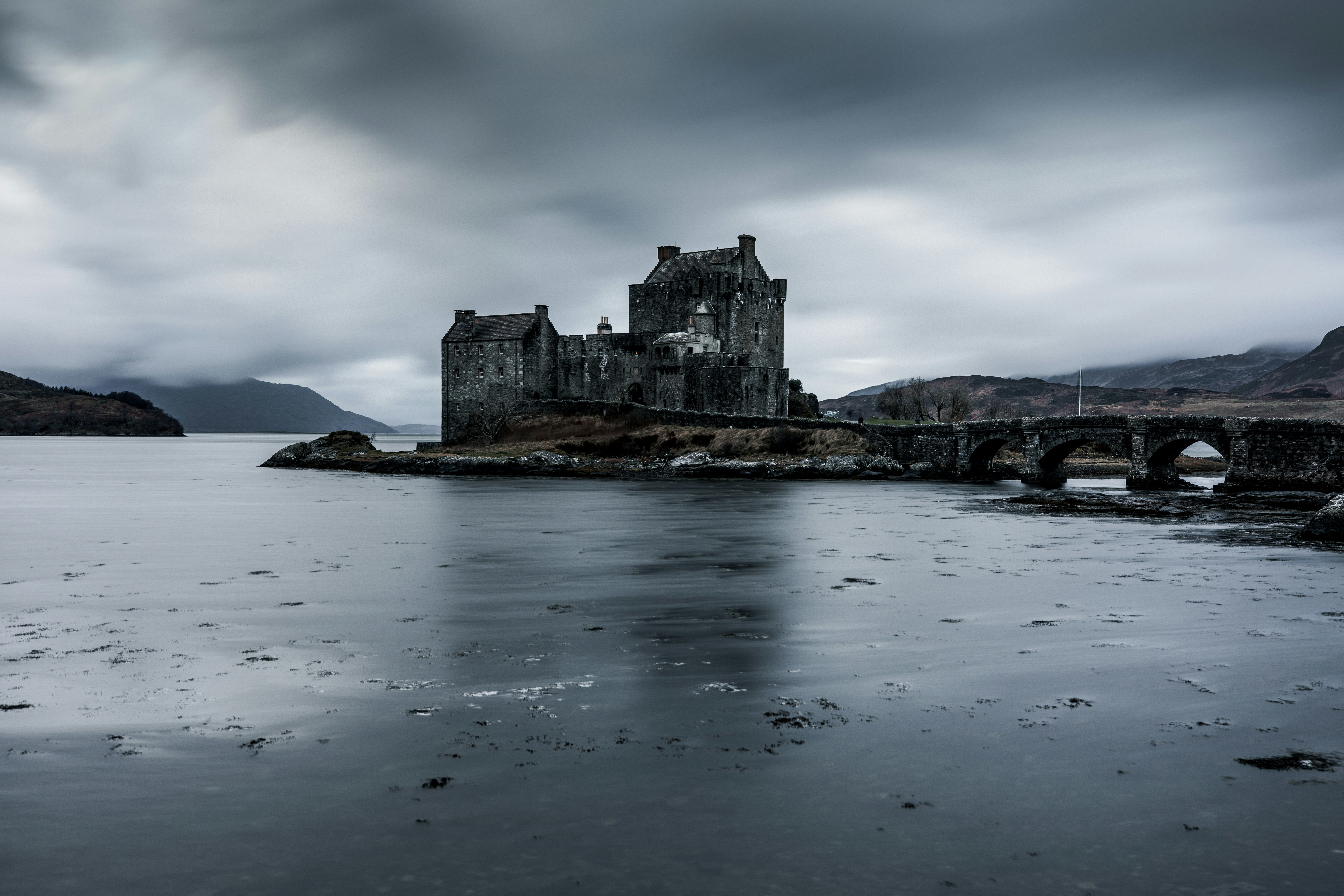 eine Burg, umgeben von einem Gewässer mit Eilean Donan im Hintergrund