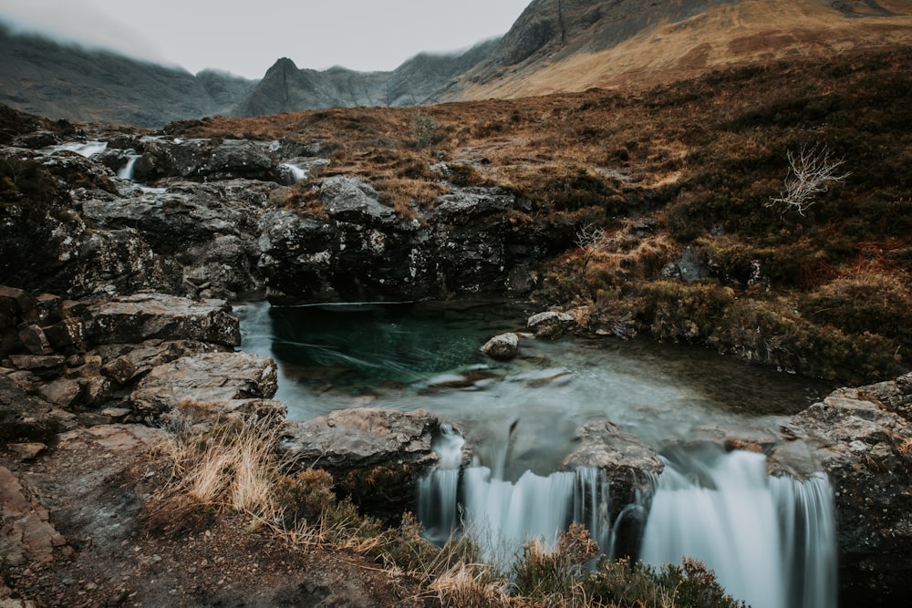 a small waterfall in the middle of a mountain