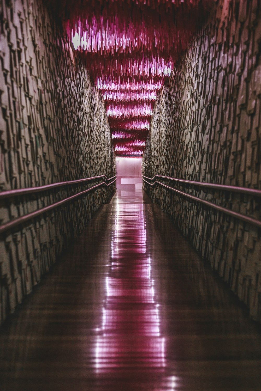a long hallway with a red light coming from the ceiling