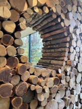 a stack of logs sitting in front of a window