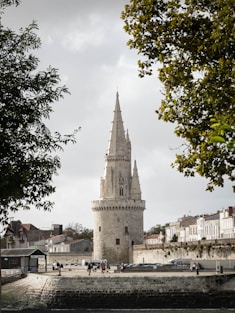 a tall tower sitting next to a river under a cloudy sky
