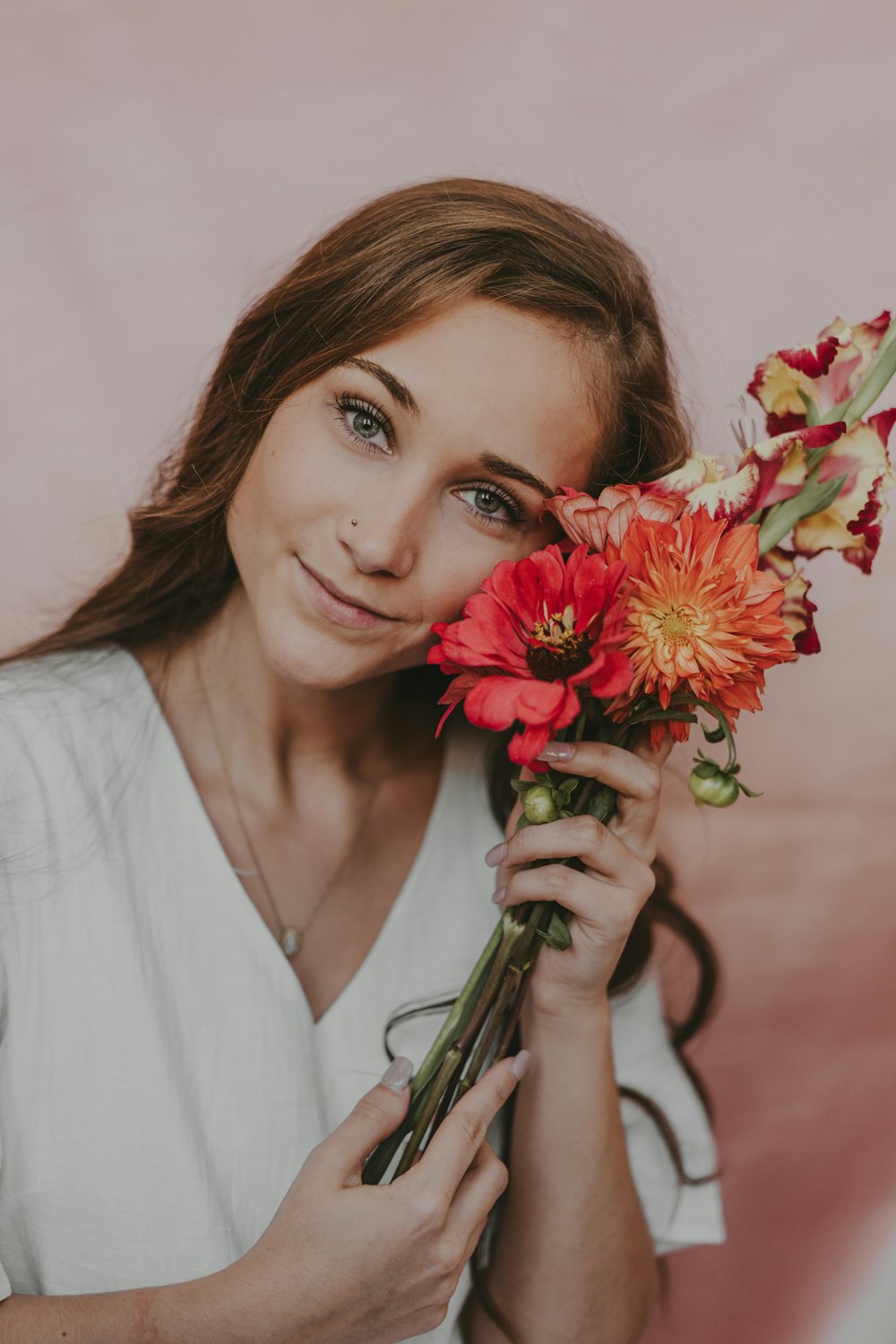 a woman holding a bunch of flowers in her hands