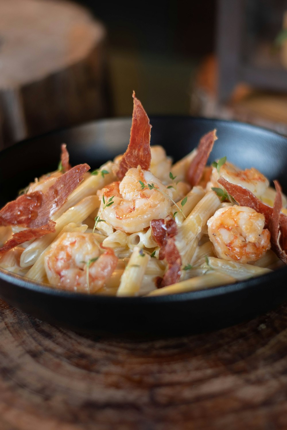 a bowl of pasta with shrimp and bacon