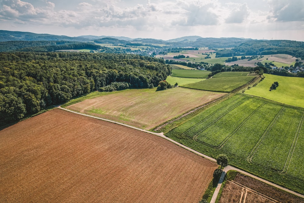 an aerial view of a large field with trees in the background