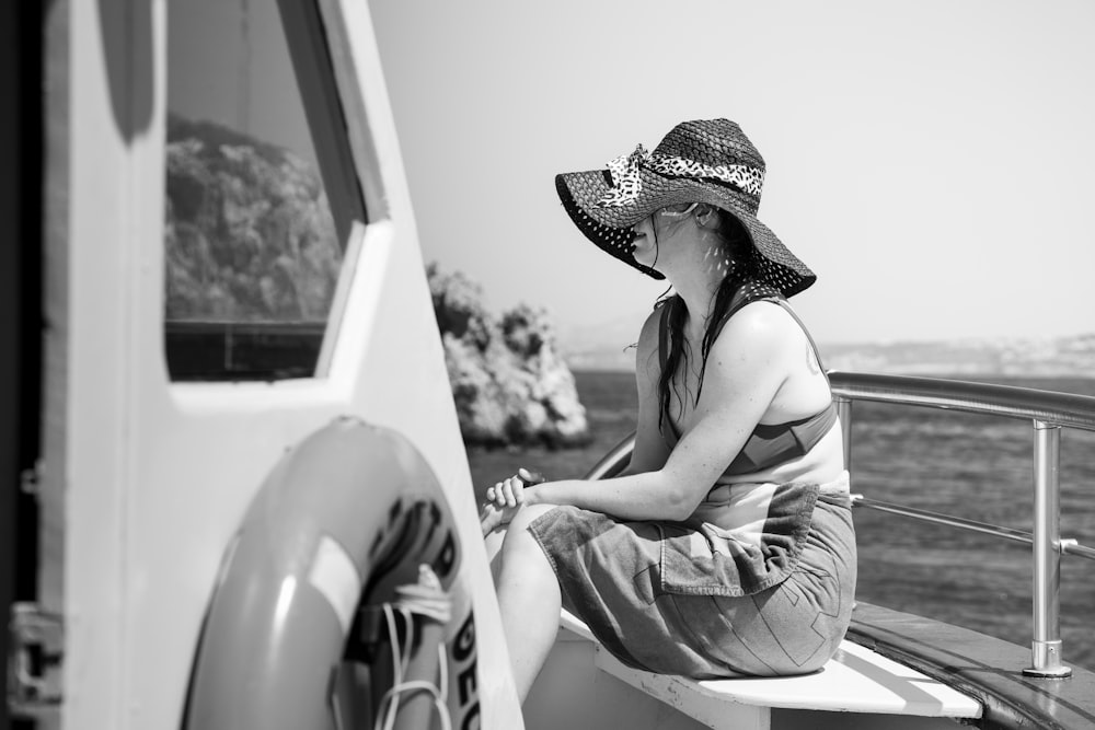 a woman in a hat sitting on a boat