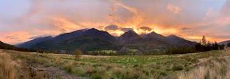 A breathtaking panoramic view of Patagonia's mountains and glaciers under a vibrant sunset.