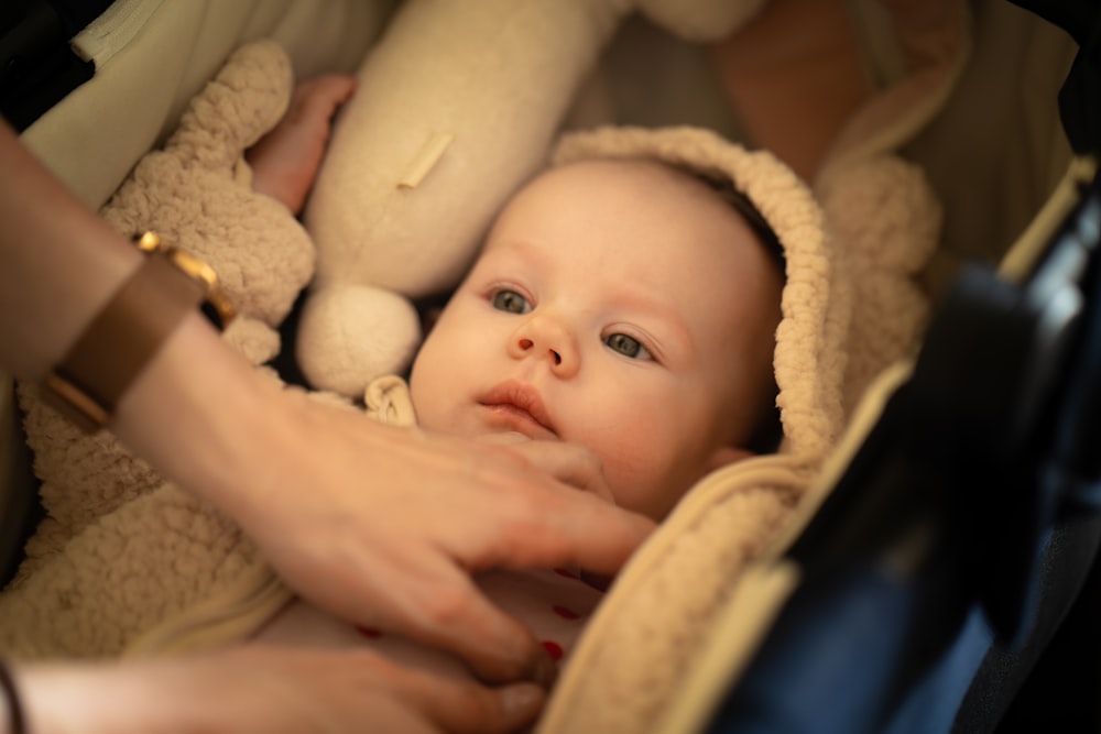 a baby in a stroller being held by a woman